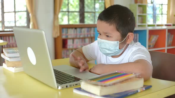 Back to School, Online learning, Asian little child with face mask using laptop alt