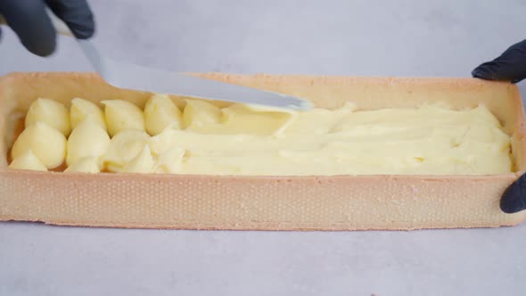 Baker Cooks Dessert Smearing Cream in Biscuit Using Spatula alt