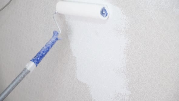Painting the Walls Covered with Wallpaper with White Paint Using Roller