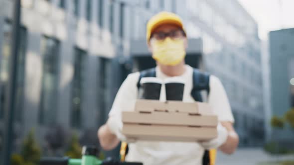 Handsome Delivery Man in Protective Face Mask Holding Stack of Pizza Cardboard alt