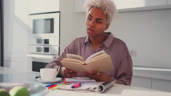 Young African American Woman Student Reading Textbook at Breakfast at Kitchen alt