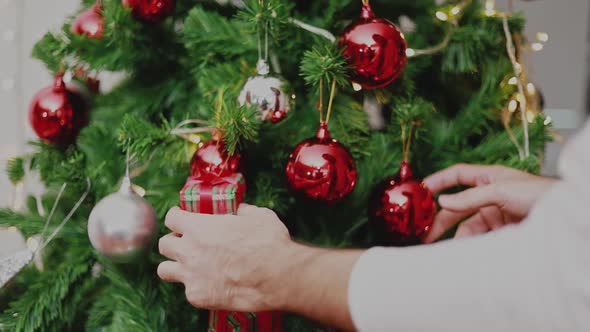 Asian man holding red ball Christmas decorate Christmas tree celebrates the new year.