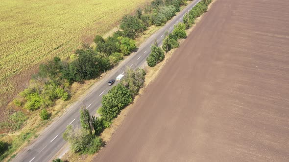 Aerial view. Highway among arable fields and sunflower fields.  