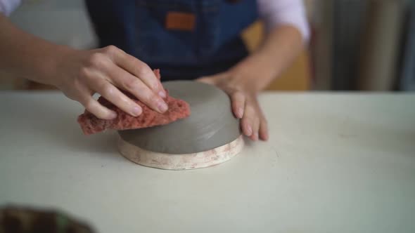 Close up female potter modeling clay bowl in workshop - Artisan work and creative craft concept alt