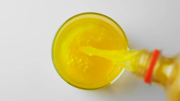 Pouring Orange Juice Soda in Glass in Slow Motion