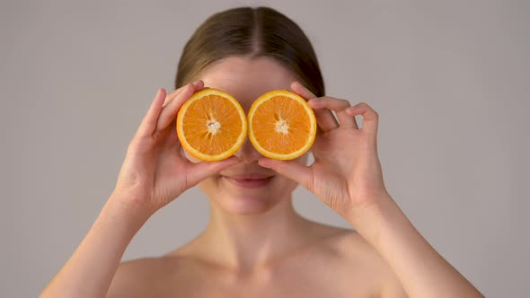 Young healthy girl with slices of orange citrus fruit