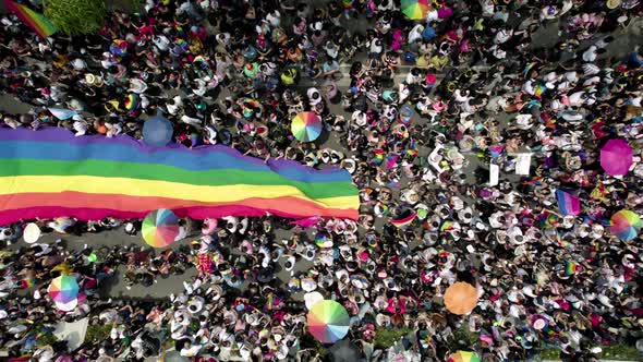 cenital drone shot of a crowd waving the gay pride flag at the pride parade in mexico city alt