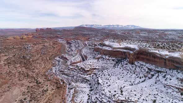 Aerial view flying towards road winding through the desert alt