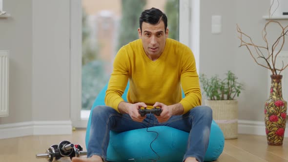 Relaxed Middle Eastern Adult Gamer Using Game Console in Slowmo and Losing in Video Game Making alt