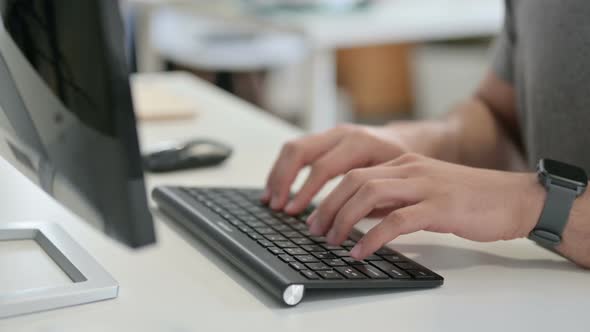 Hands of Young Man Typing on Keyboard Close Up alt