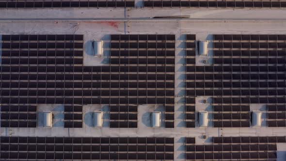 Aerial shot of solar panels covers the roof of a large building alt