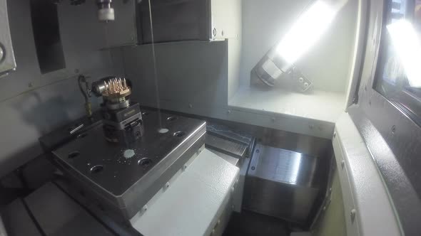 milling shapes out of a metal piece on a CNC machine alt