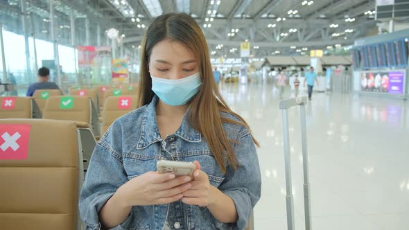 asian tourist traveller weaar protective face mask sit wait in new space social distancing alt