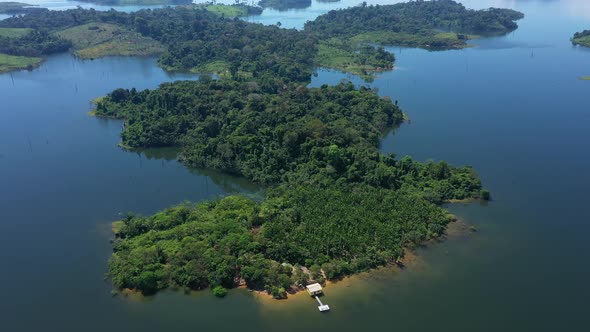 Drone Soaring Up, Revealing An Island, Surrounded By Blue Water