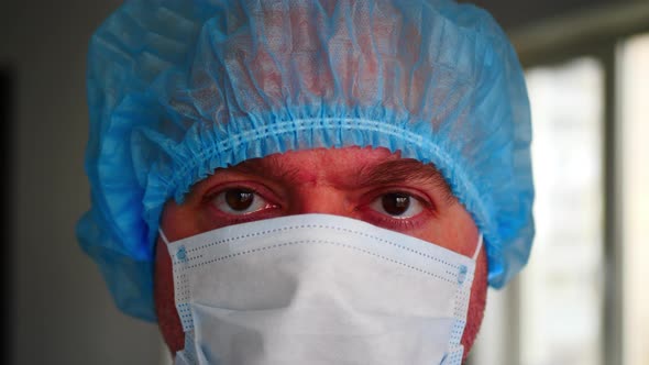 Tired Professional Doctor In Medical Disposable Face Mask And Blue Medical Cap