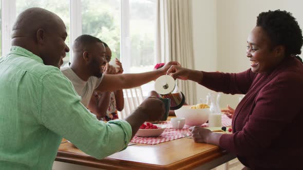 Three generation african american family having breakfast together at home alt