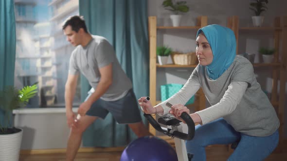 Close Up Athletic Muslim Couple Sports in Their Living Room at Home alt