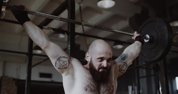 Closeup Slow Motion Shot of Young Caucasian Man Lifting Crossbar in Large Gym Hall Extreme Heavy alt