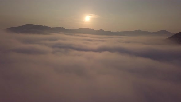 Aerial drone view of foggy sunrise over clouds hills and mountains at morning Carpathian mountains