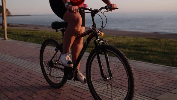 Young Woman in Sportswear Protective Helmet Cycling and Pedaling in Park alt