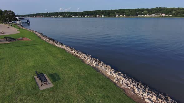 A drone rises above an empty park bench looking over the mighty Mississippi river. alt