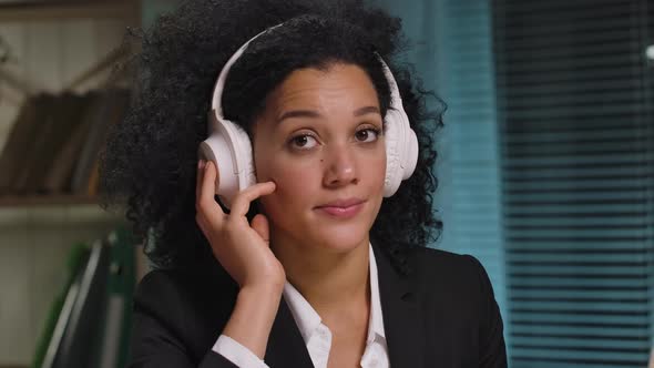 Portrait of African American Woman Listens to Music in Big White Headphones alt