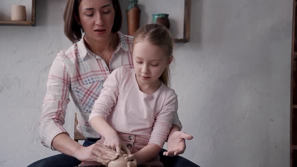 Little Kid Girl with Adult Mother Working with Clay in Pottery
