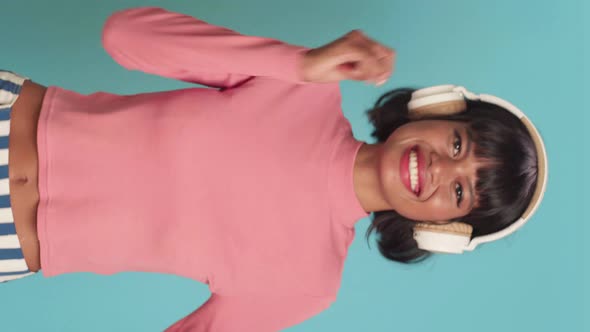 Vertical Video of Joyful Dark Skinned Woman Listens Music in Headphones alt