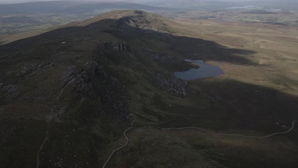 Hills And Mountain Slopes With A Small Lake In Cuilcagh Boardwalk Trail, Northern Ireland. Aerial Dr alt