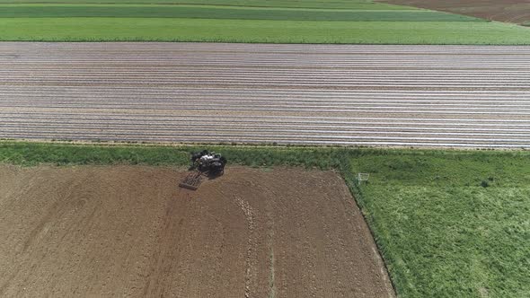 Aerial View of Amish Farm Worker Harvesting Spring Crop With Team of 6 Horses alt