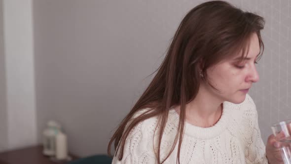 Taking a Dose of Painkiller. The Girl in the Bedroom Is Drinking a Cold Pill. Pharmaceutical and alt