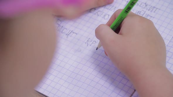 Young Children Write Russian Words in Notebooks