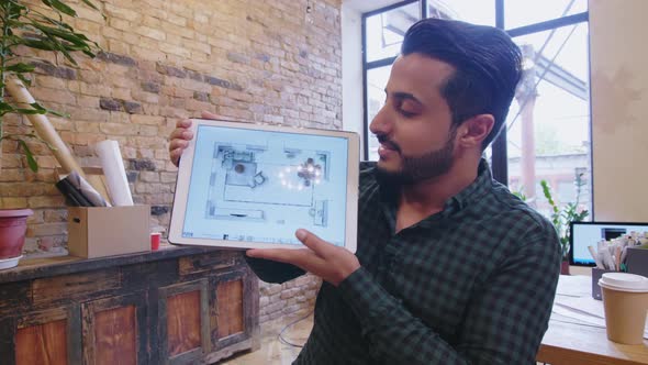 Middle Eastern Designer Presenting Interior Plan on Tablet at Camera