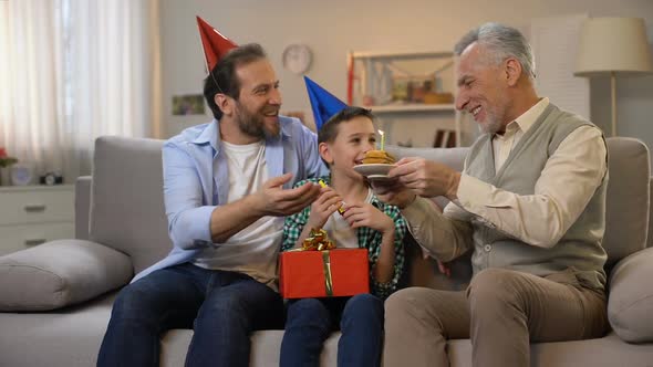 Middle-Aged Male and Preteen Boy Congratulating Grandpa With ...
