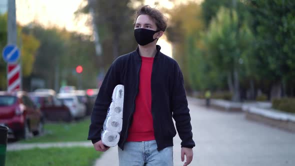 Teen Walking in Medical Mask with Toilet Paper During the Second Wave Quarantine Coronavirus COVID alt