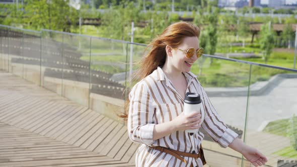 Stylish Women with Coffee Walk Along Contemporary City Park