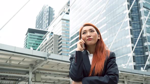 Smart Business Woman Talking on the Mobile Phone with Smiling Over Building Cityscape Background alt