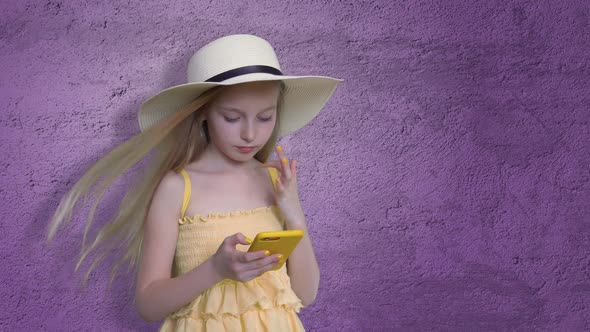 Girl Posing with Mobile Phone on Violet Background alt