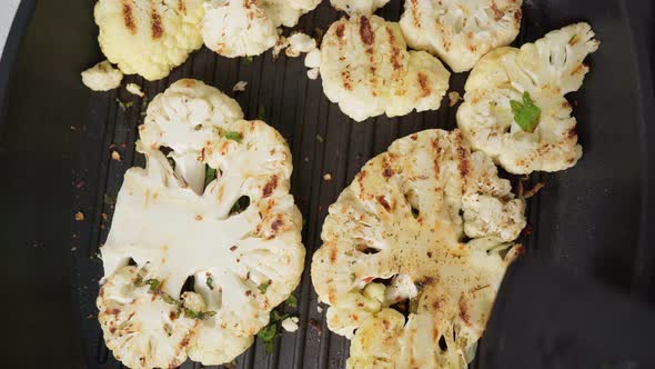 Cauliflower Steak with Spices Cooks on a Grill Pan in Closeup alt