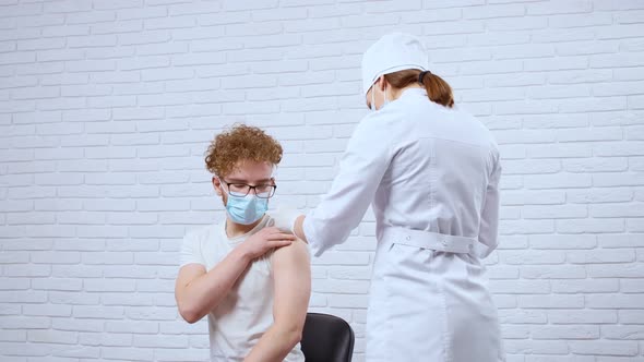 Young Nurse Giving Vaccine Covid2019 for Young Man alt