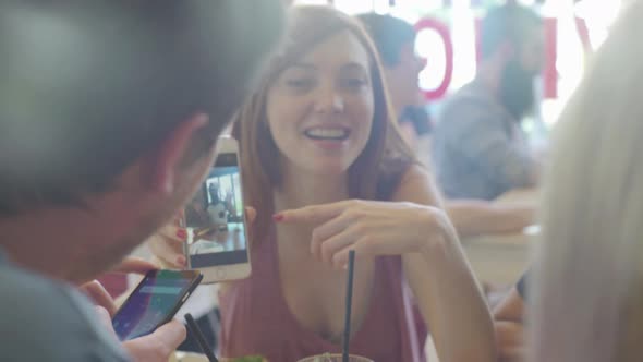 Woman showing image displayed on smartphone to friends