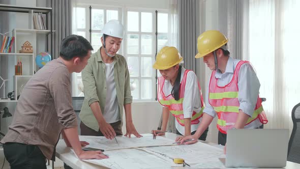 Three Asian Engineers With Helmets Presenting Work To A Man At The Office alt