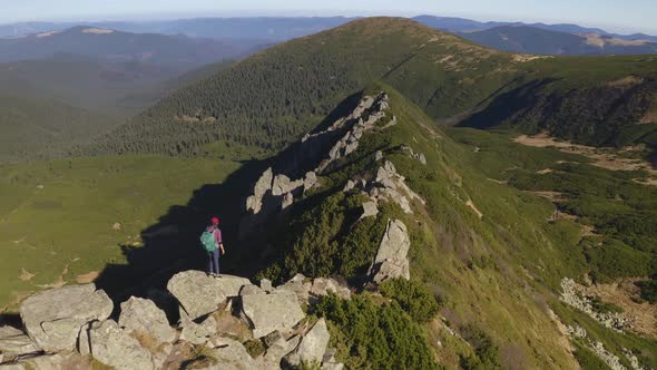 Aerial View of Hiker Woman with Backpack on Top of a Mountain alt