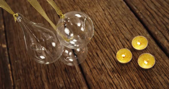 Tealight candles with hanging glass lamps on a plank 4k alt