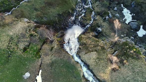 Aerial video of a waterfall along the Klausen Pass in Switzerland. alt