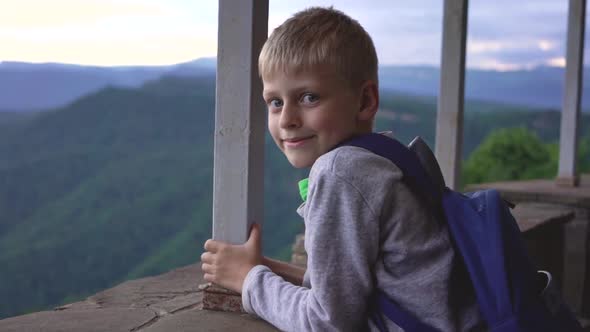 Child on the Background of Mountains