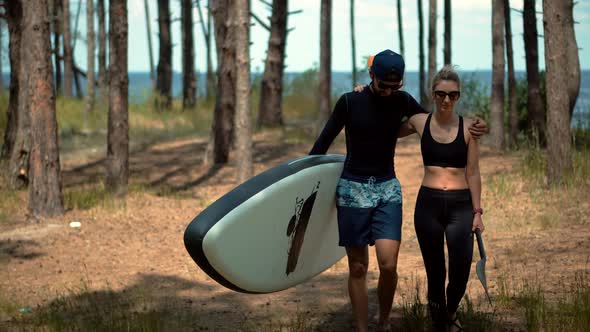 Travel Water Tourism Holiday Vacation. Sport Recreation Sup Fun Rowing. Couple Carries Sup Board. alt