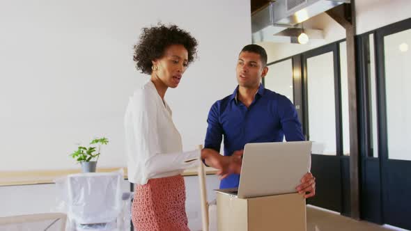 Business people discussing over laptop in modern office 4k alt