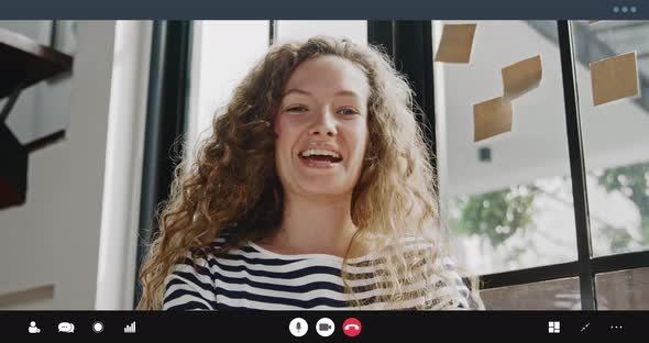 Pretty Caucasian woman waving hand at the camera and talking on video call at home