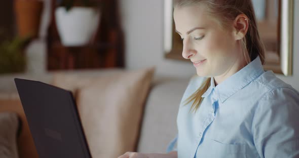 Smiling Woman Working on Laptop at Home Office. Businesswoman Typing on Computer Keyboard alt